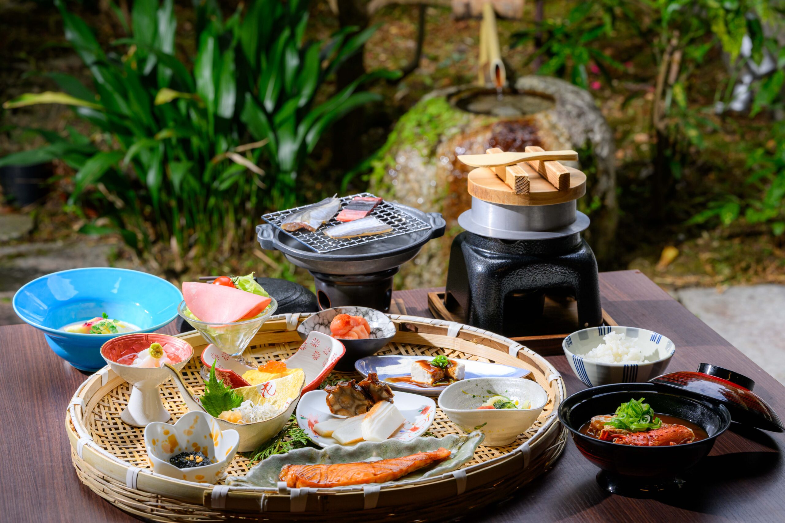 お一人様分ずつ、釜炊きのごはんをご用意しております。旬の魚をじっくりと焼き上げ、彩り豊かな季節の菜（おかず）をかご盛りに設えました。 日本の豊かな四季を感じる、滋味深い味わいをご堪能ください